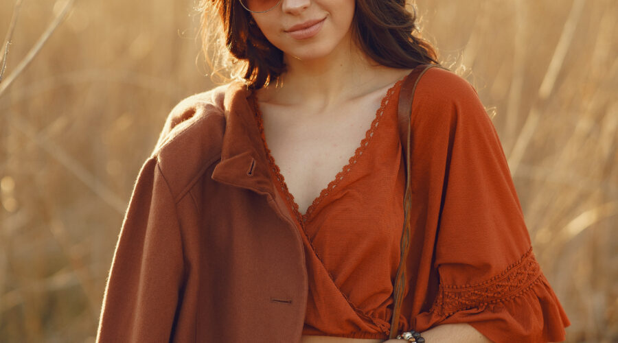 Ragazza con camicia arancione, gonna giallo ocra e cappotto marrone