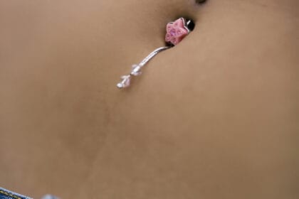 piercing all'ombelico con gioiello a forma di stella rosa e ciondoli con perline trasparenti