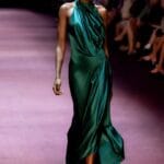 Modella sfila con vestito in raso drappeggiato verde smeraldo, colore di tendenza 2025