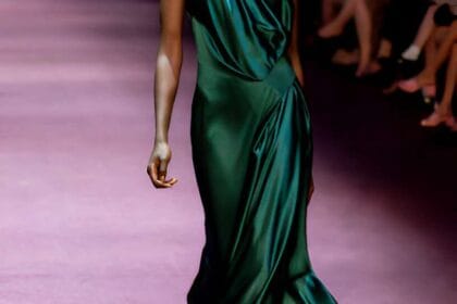Modella sfila con vestito in raso drappeggiato verde smeraldo, colore di tendenza 2025