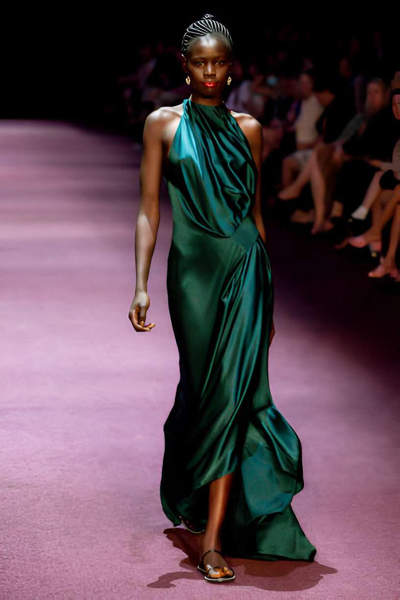 Modella sfila con vestito in raso drappeggiato verde smeraldo, colore di tendenza 2025