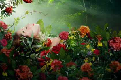 Donna rilassata ricoperta di fiori ed erbe, simbolo del benessere