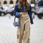 Ragazza con giacca crop in denim e pantaloni cargo beige, capi must have per la primavera