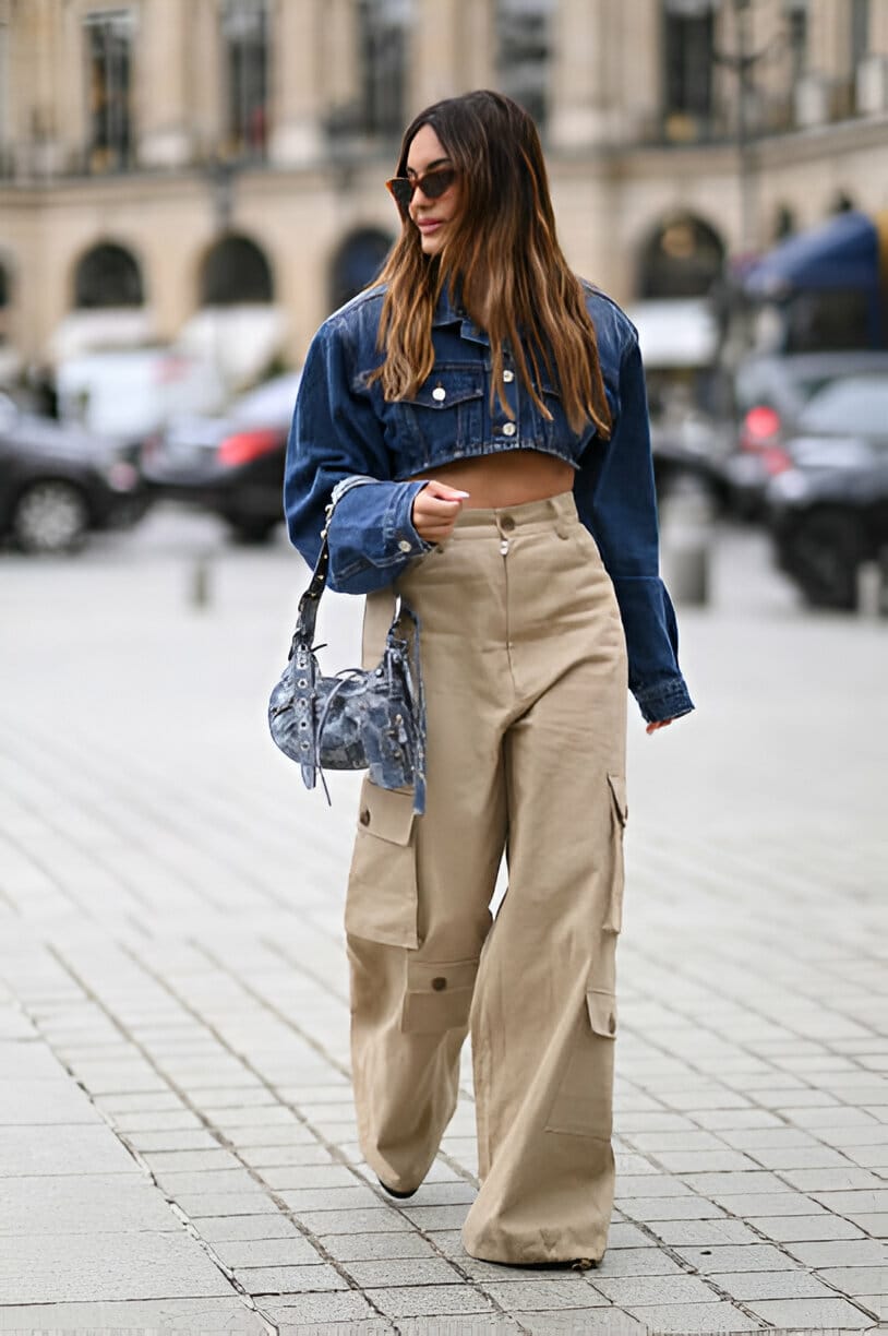 Ragazza con giacca crop in denim e pantaloni cargo beige, capi must have per la primavera