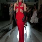 donna indossa un vestito lungo elegante di colore rosso e guanti da sera lunghi neri