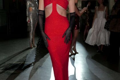 donna indossa un vestito lungo elegante di colore rosso e guanti da sera lunghi neri