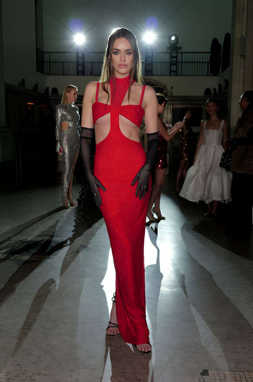 donna indossa un vestito lungo elegante di colore rosso e guanti da sera lunghi neri