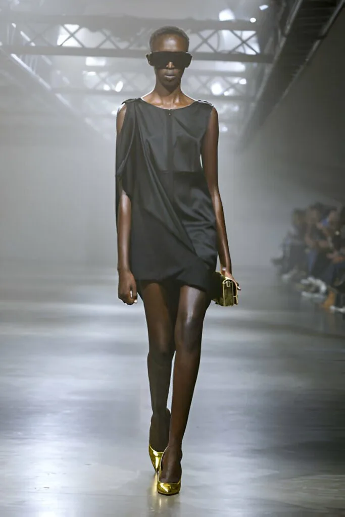 Modella con mini dress nero e accessori dorati
