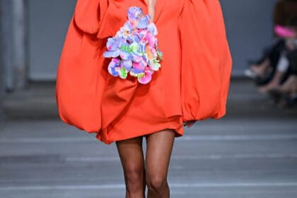 Modella sfila in abito arancione. L'arancione e il giallo citron sono colori vitaminici di tendenza.