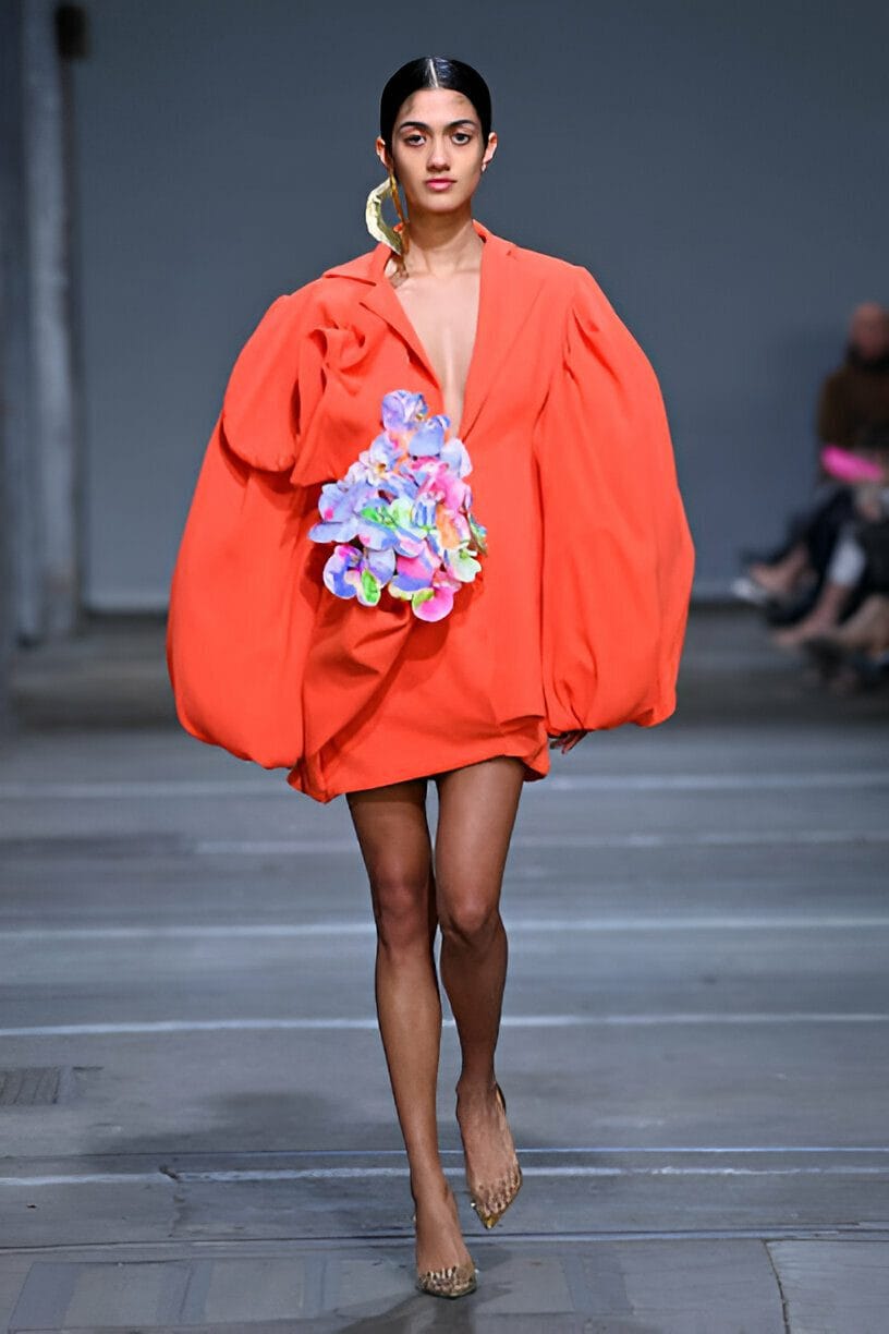 Modella sfila in abito arancione. L'arancione e il giallo citron sono colori vitaminici di tendenza.