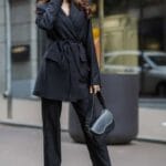 Donna in tailleur nero esprime stile e sicurezza di sé
