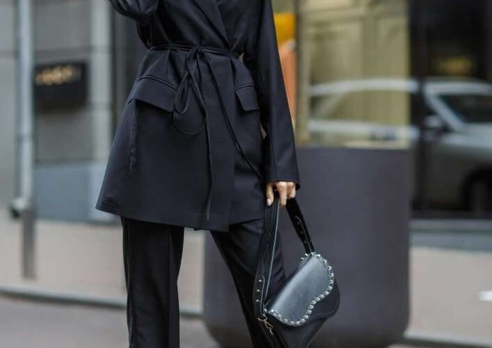 Donna in tailleur nero esprime stile e sicurezza di sé