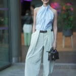 Ragazza con top azzurro halter e pantaloni ampi verde menta, capi e colori di tendenza primavera/estate 2025