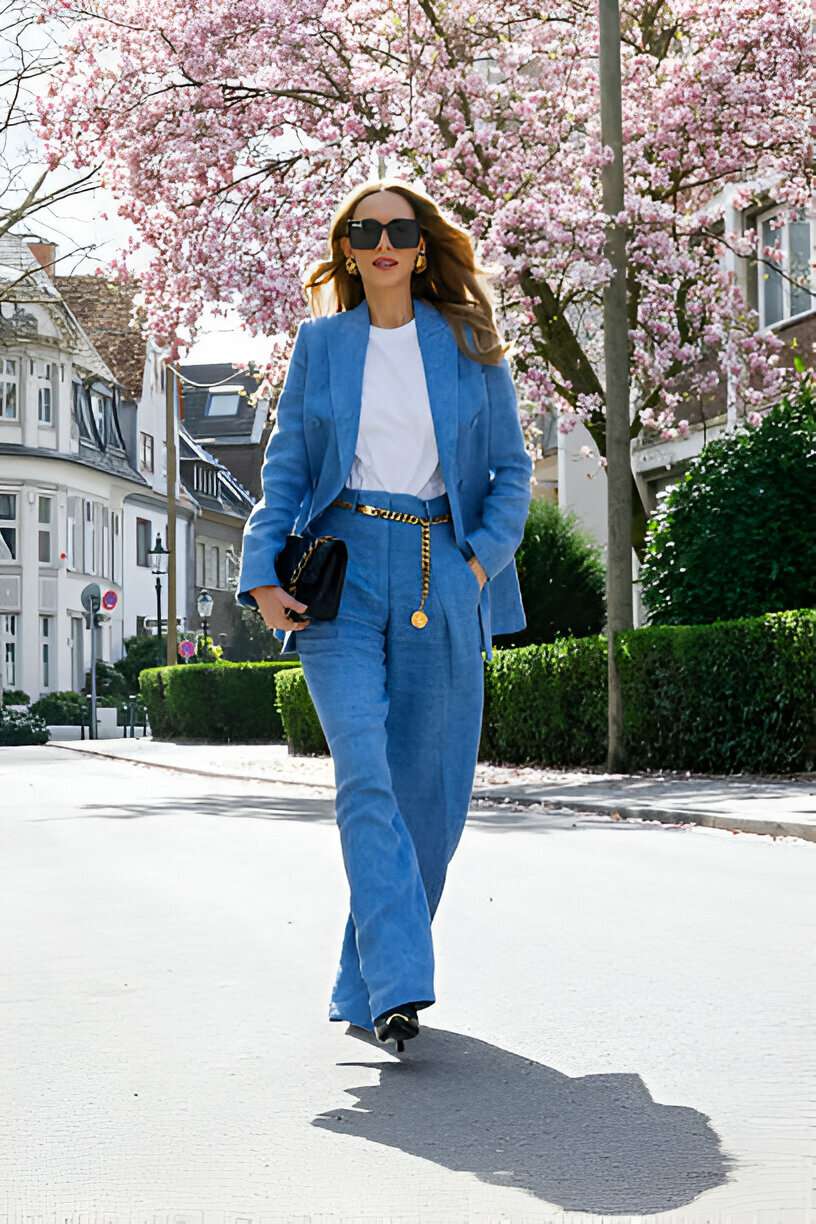 Donna vestita con stile indossa un completo azzurro composto da blazer e pantaloni