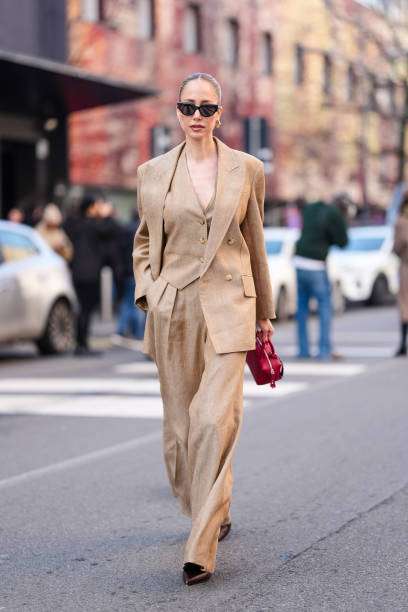 Donna con tailleur elegante beige e borsa rossa