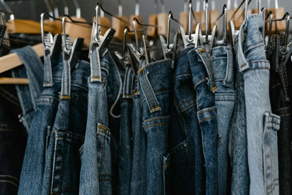 Fila di jeans tutti uguali disposti su grucce