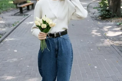 Ragazza in un parco indossa jeans balloon e maglietta bianca