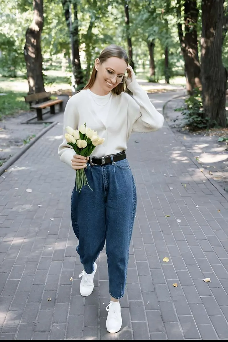 Ragazza in un parco indossa jeans balloon e maglietta bianca
