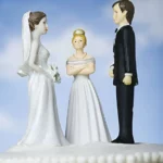 Torta nuziale con decorazione degli sposi uno di fronte all'altro e, in mezzo, una suocera invadente.