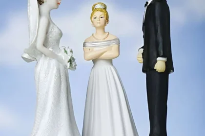 Torta nuziale con decorazione degli sposi uno di fronte all'altro e, in mezzo, una suocera invadente.