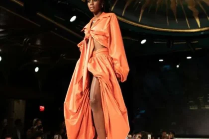 Modella sfila con un outfit arancione e scarpe décolleté verde smeraldo