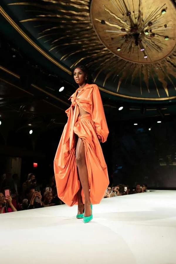 Modella con abito arancione in una sfilata di moda