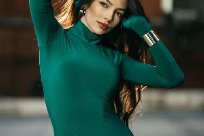 Donna con abito aderente verde smeraldo e bracciali dorati