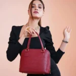 Donna con tubino nero e borsa strutturata rossa per un look minimal chic