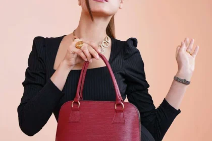 Donna con tubino nero e borsa strutturata rossa per un look minimal chic