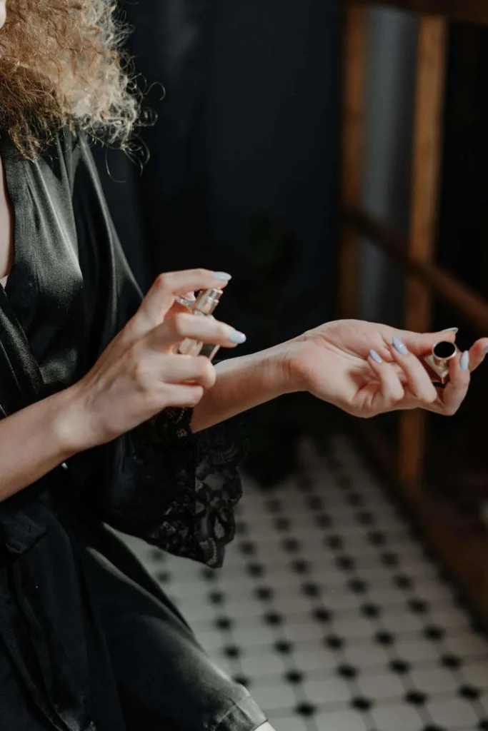 Donna spruzza il profumo sui polsi
