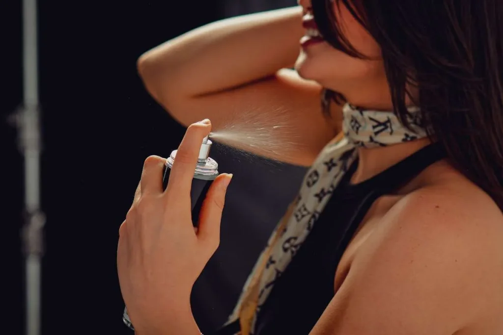 Ragazza spruzza un profumo sul collo