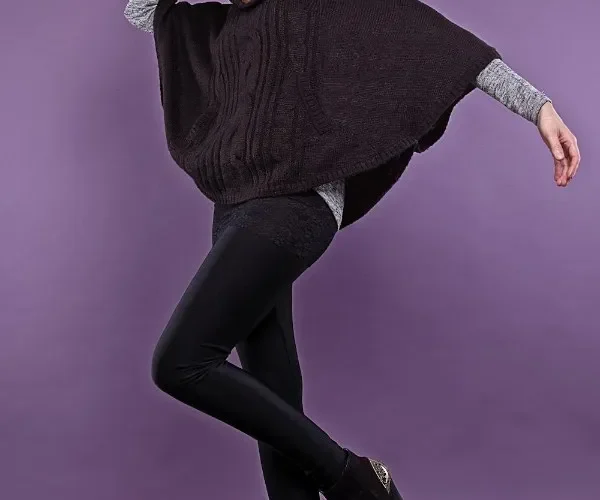 Donna con poncho marrone, leggings e stivaletti neri.