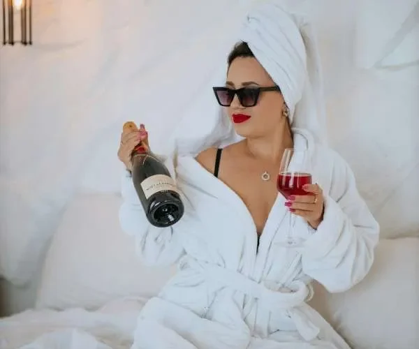 Donna single festeggia felicemente San Valentino con pizza, calice di vino, riviste di moda.