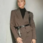 Una donna indossa un blazer oversize marrone stretto in vita da una cintura in pelle nera.