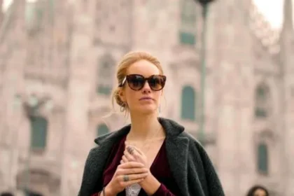 Donna elegante con borse di boutique a Milano: esempio di shopping consapevole e di qualità durante i saldi.