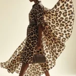 Modella indossa ampio abito con stampa animalier leopardata e scarpe con tacco alto a stiletto