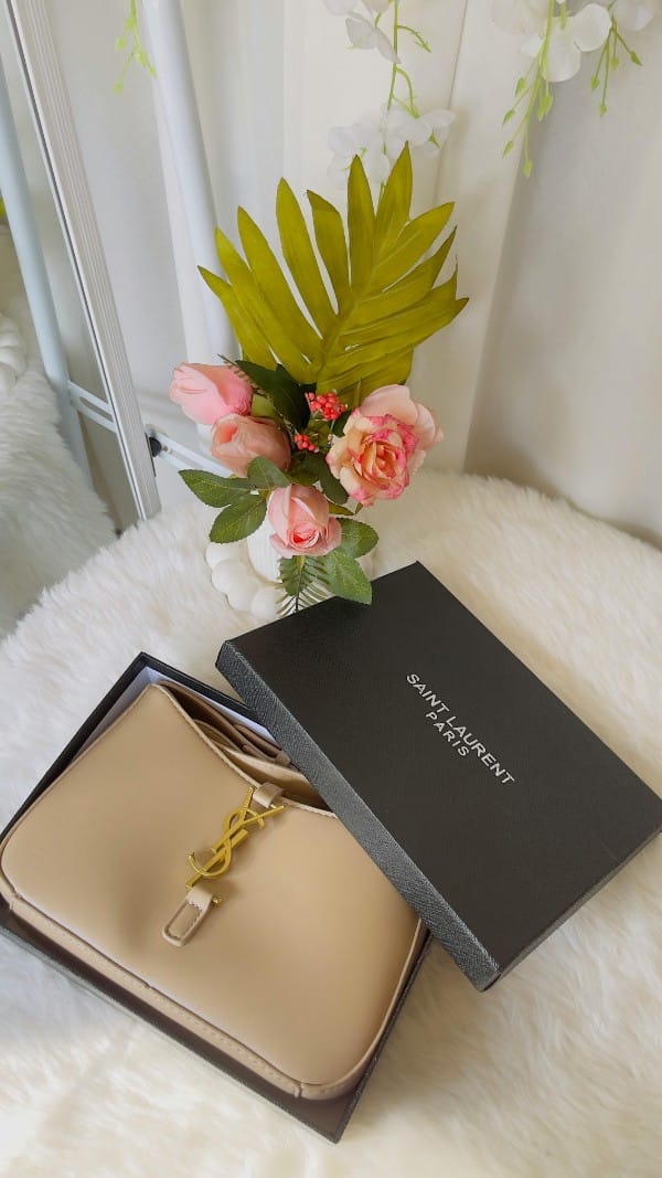 Borsa Saint Laurent beige in scatola aperta, fiori e dettagli luxury - Guida borse di lusso 2026.