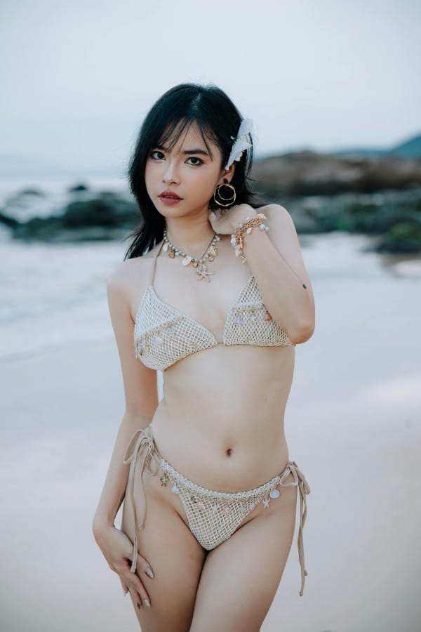 Ragazza indossa costume da bagno bikini a crochet ornato con piccoli ciondoli