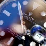 Dettaglio ravvicinato del quadrante di un Rolex Submariner pre-owned, con focus sulla lente Cyclope e le lancette per la verifica dell'autenticità.