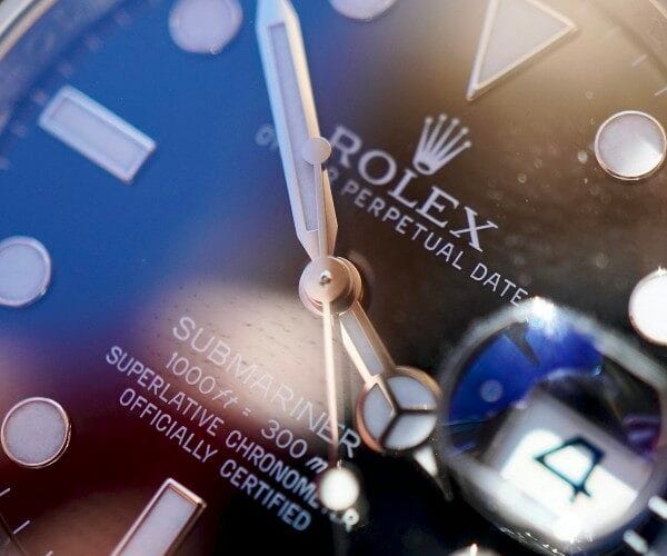 Dettaglio ravvicinato del quadrante di un Rolex Submariner pre-owned, con focus sulla lente Cyclope e le lancette per la verifica dell'autenticità.