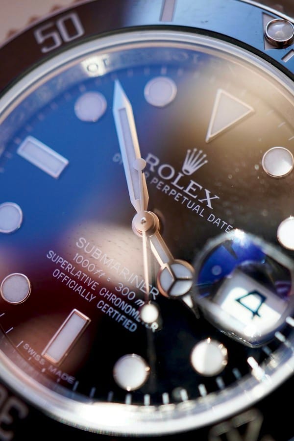 Dettaglio ravvicinato del quadrante di un Rolex Submariner pre-owned, con focus sulla lente Cyclope e le lancette per la verifica dell'autenticità.