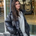 Ragazza indossa un giubbino oversize tra i 5 modelli di giubbini invernali di tendenza in colore grigio scuro, jeans e felpa oversize bianca