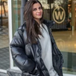 Ragazza indossa un giubbino oversize tra i 5 modelli di giubbini invernali di tendenza in colore grigio scuro, jeans e felpa oversize bianca
