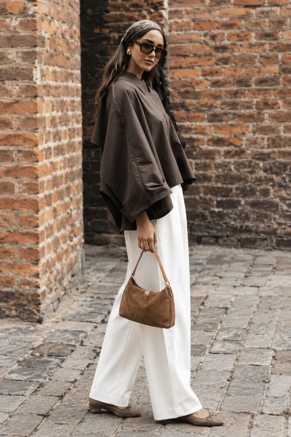 Look quiet luxury ispirato a Massimo Dutti con giacca marrone, pantaloni bianchi sartoriali, ballerine a punta e borsa cammello in suede.